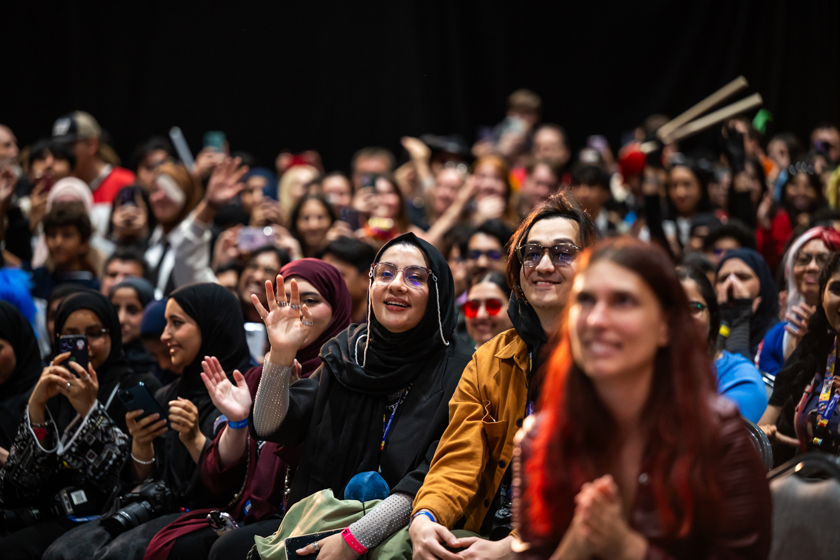 Audience in cosplay applauding and filming during a live screening at MEFCC, showcasing excitement and fan engagement at the Main Stage.