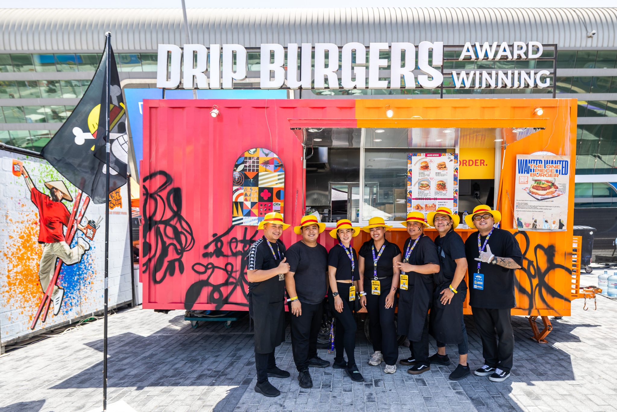 Cosplayers dressed as Deadpool, Captain America, and anime characters ordering food at the MEFCC Food Truck Park, in front of the PizzaExpress stall.