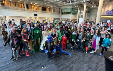 a large group of cosplayers posing for a big group photo.