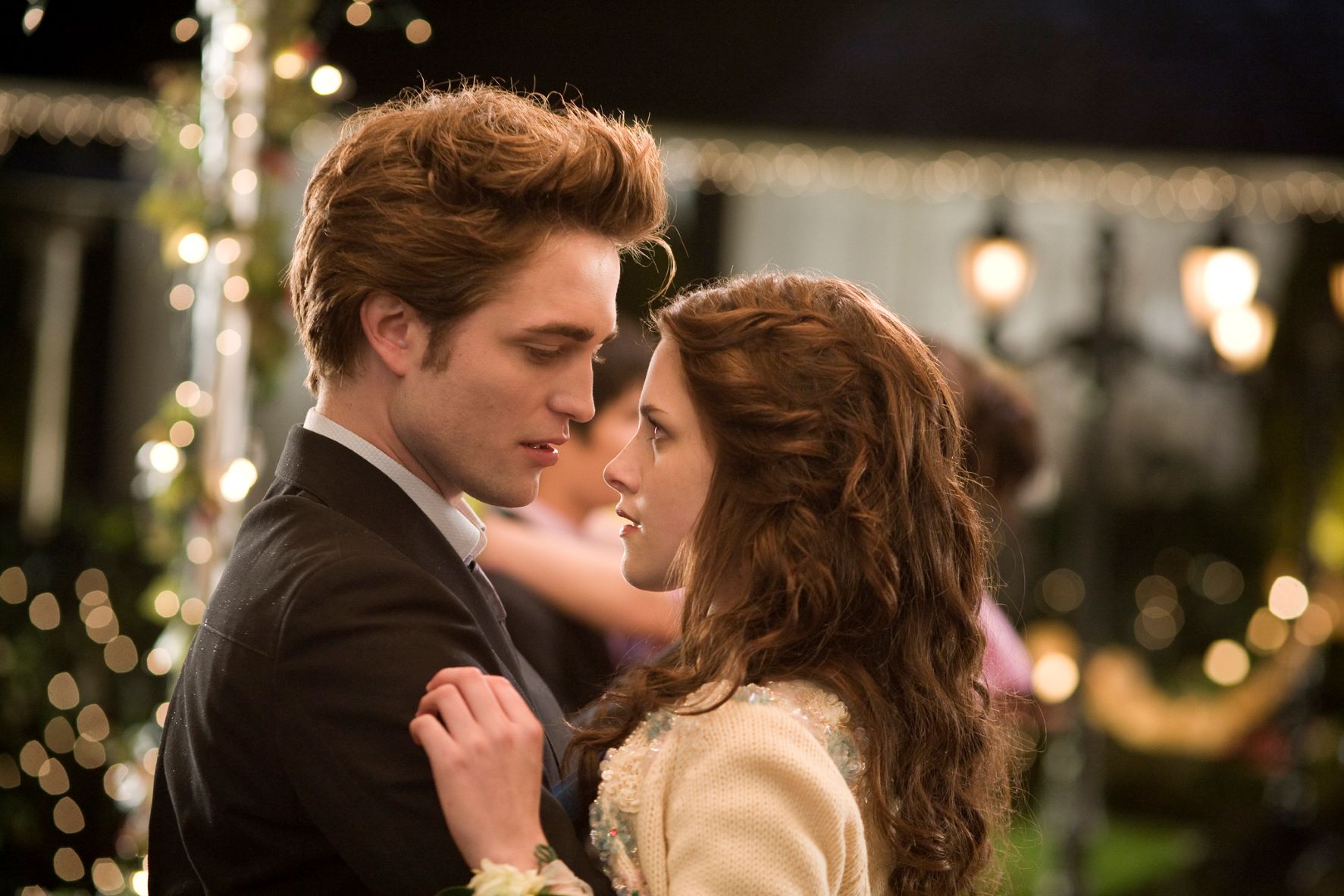 Bella and Edward are dancing together and staring deeply into each other's eyes.