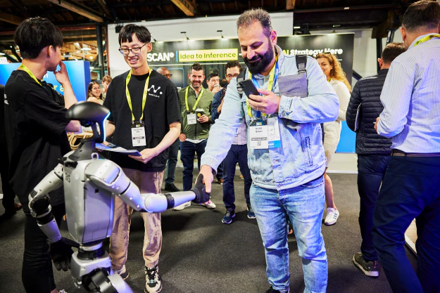 A man interacts with a robot at The AI Summit expo space