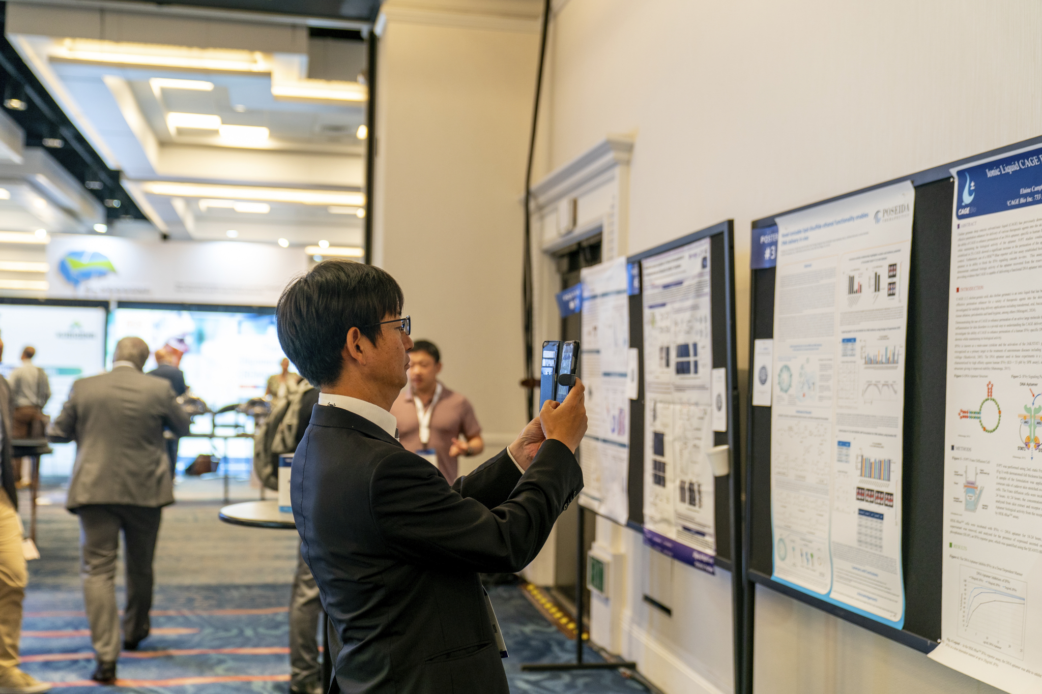Man taking photo of a scientific poster inTIDES USA Poster Hall