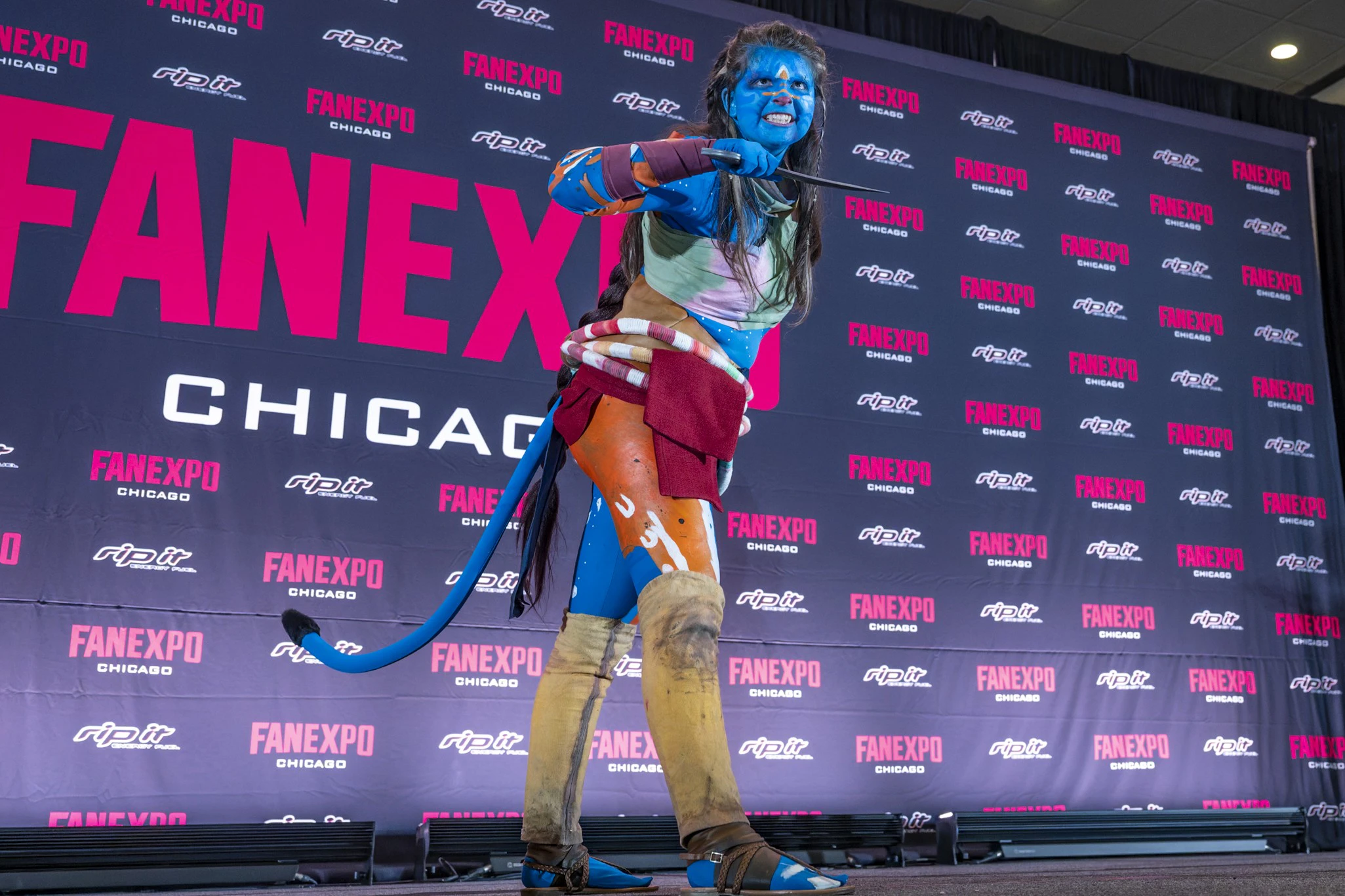 Four cosplayers stand together on stage, one in a bright armored pig-inspired costume holding a “Runner-Up” certificate while the others in colorful period and fantasy outfits smile beside them.