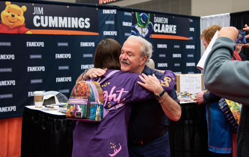 Voice Actor Jim Cummings hugging a fan at his autograph booth