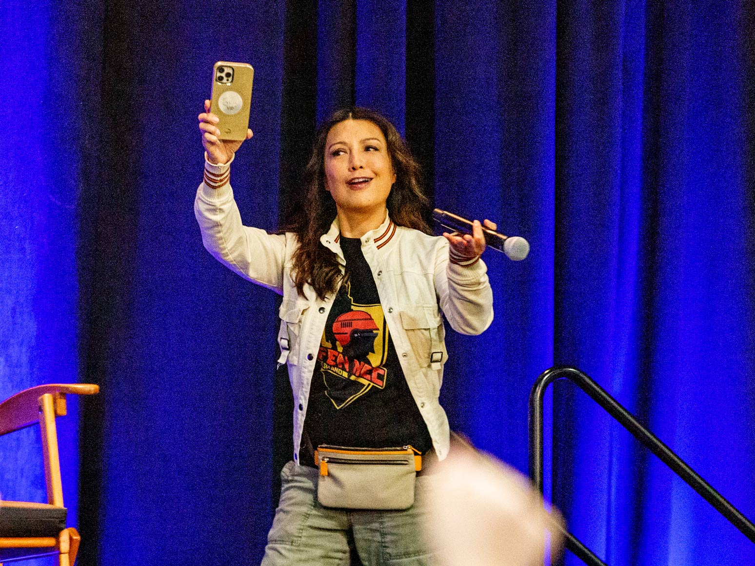 Ming-Na Wen on stage holding a phone