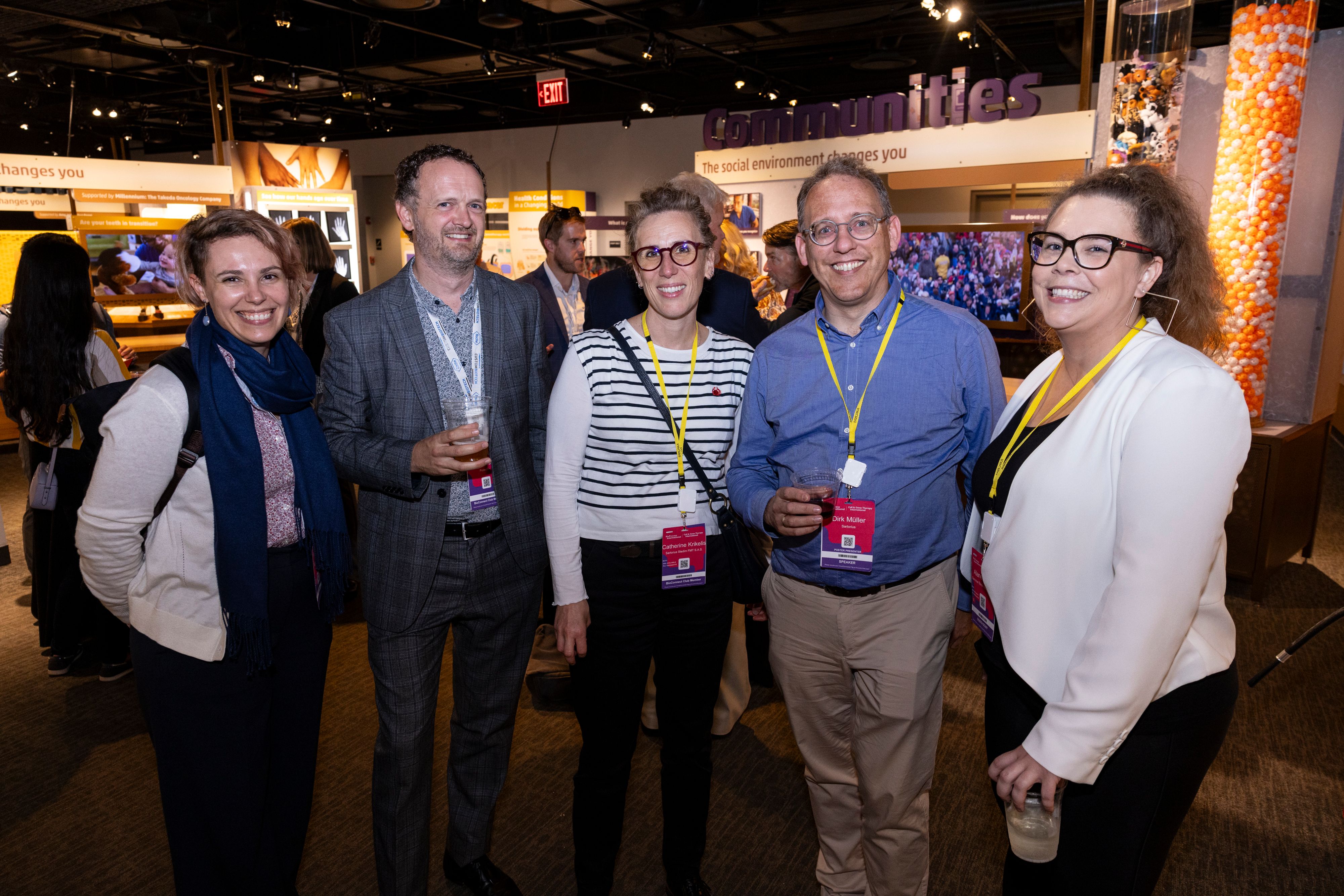 Five BioTech Week Boston bioprocessing professionals smile for a picture in the exhibit hall.