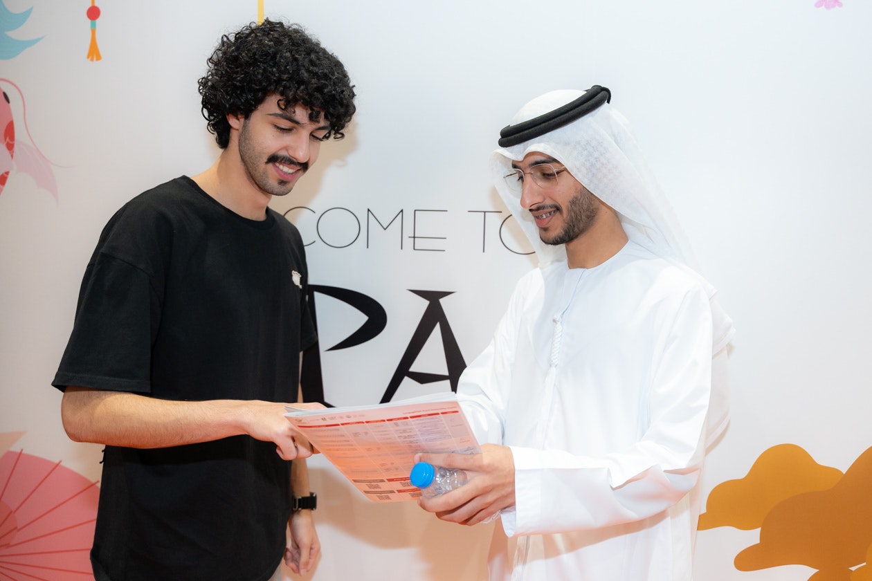 Emirati student receives admissions guidance from a university representative at Najah Abu Dhabi higher education exhibition.
