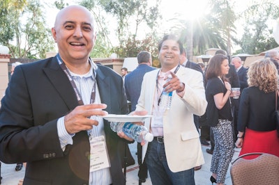 Two men smiling and mingling over food