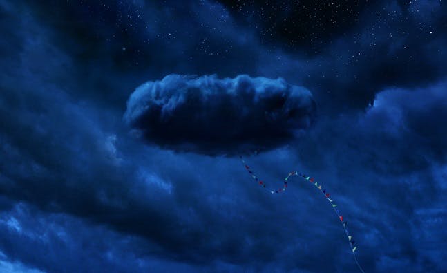A large cloud with a kite tail sticking out of it sticks distinctively out from a sky full of other clouds