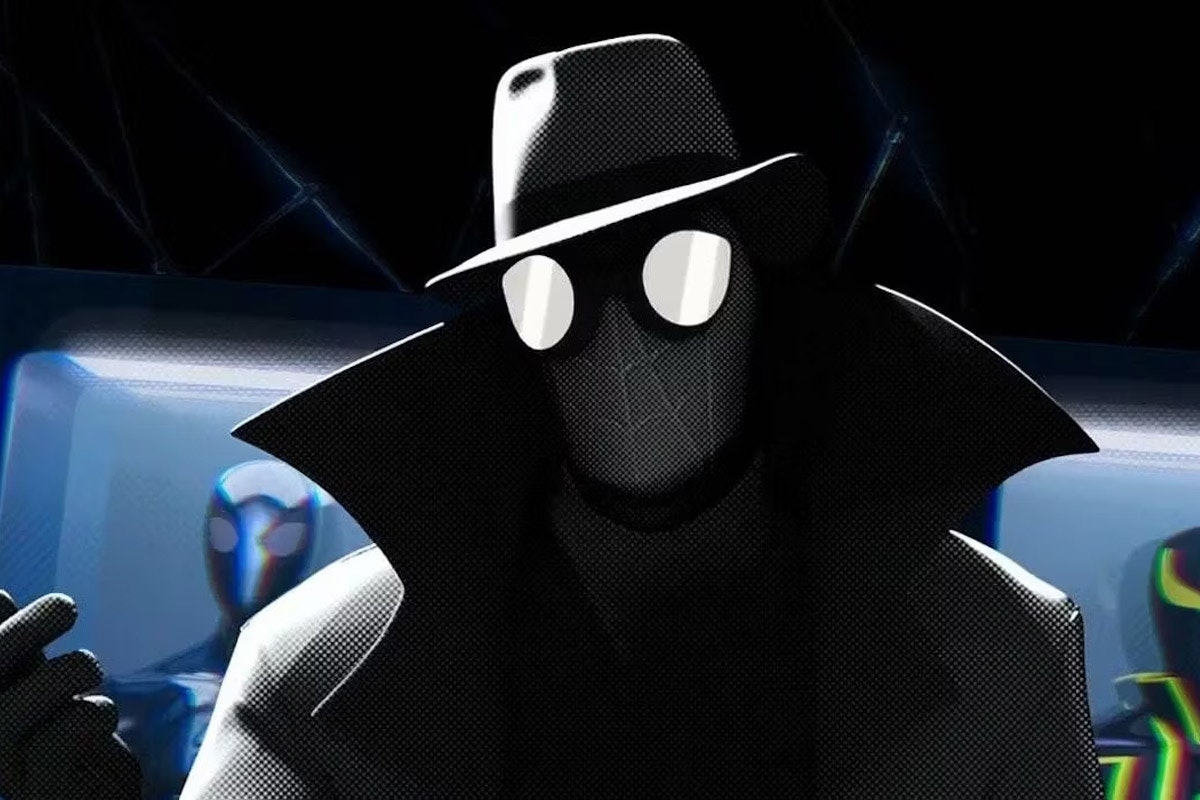 Spider-noir stands among Spider-suits and holds his hand up