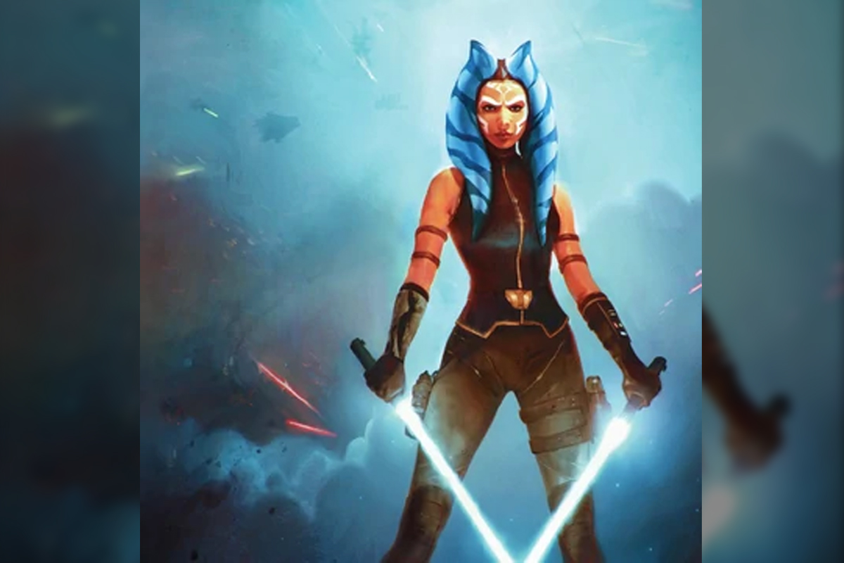 Star Wars character Ahsoka stands in a blue/grey field of smoke with her two white lightsabers ignited and facing downward in a 'V' shape