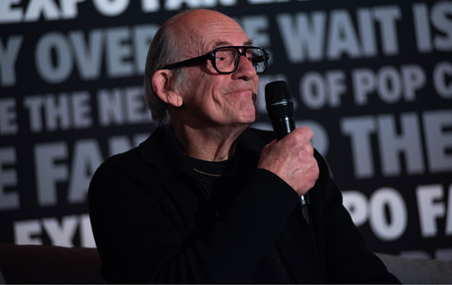 Christopher Lloyd smiling and holding a microphone to his mouth