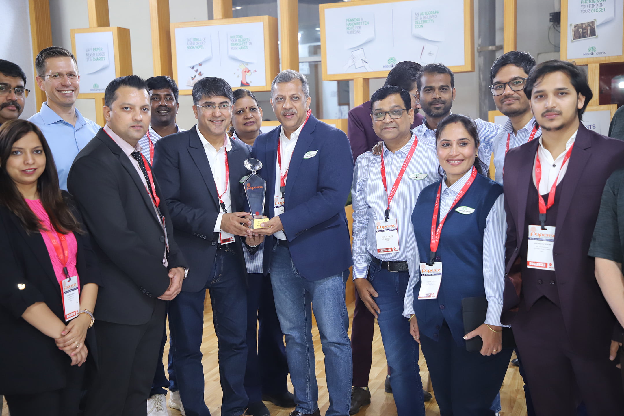 Group of professionals at an award ceremony with someone holding a trophy.