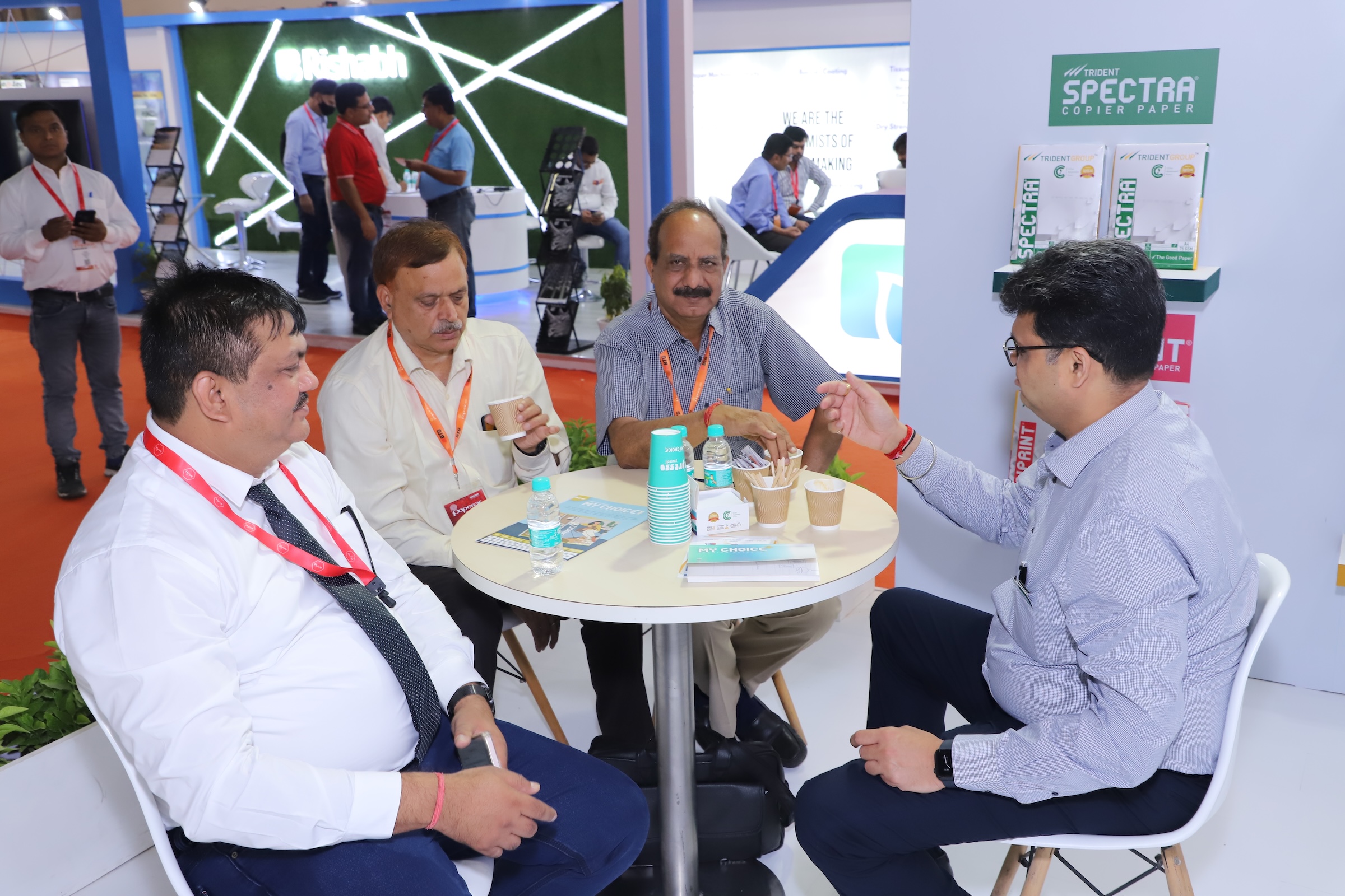 Business meeting at a trade show or conference with people seated at a small table.