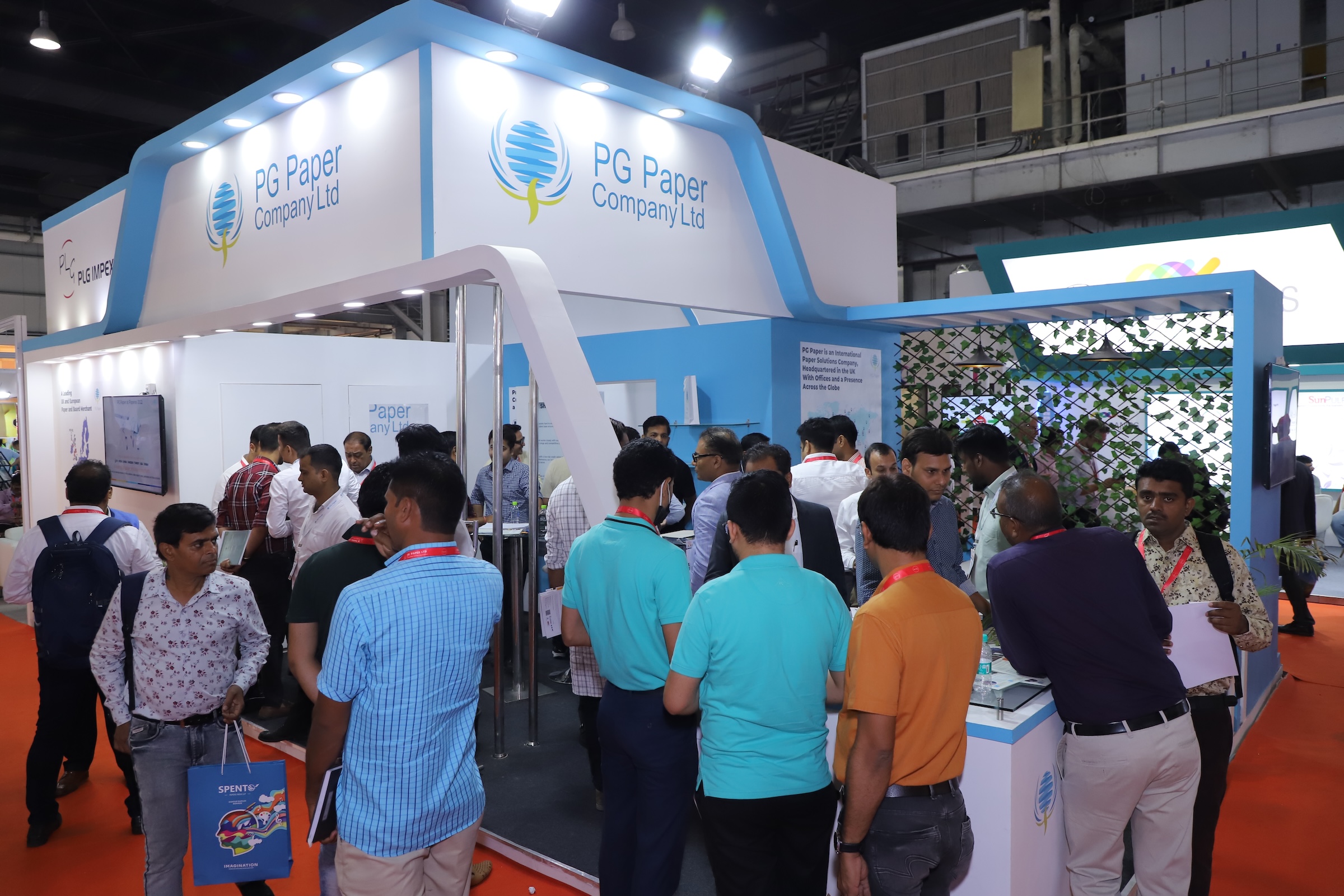 Attendees walking through the corridor, exploring various booths on display at Paperex