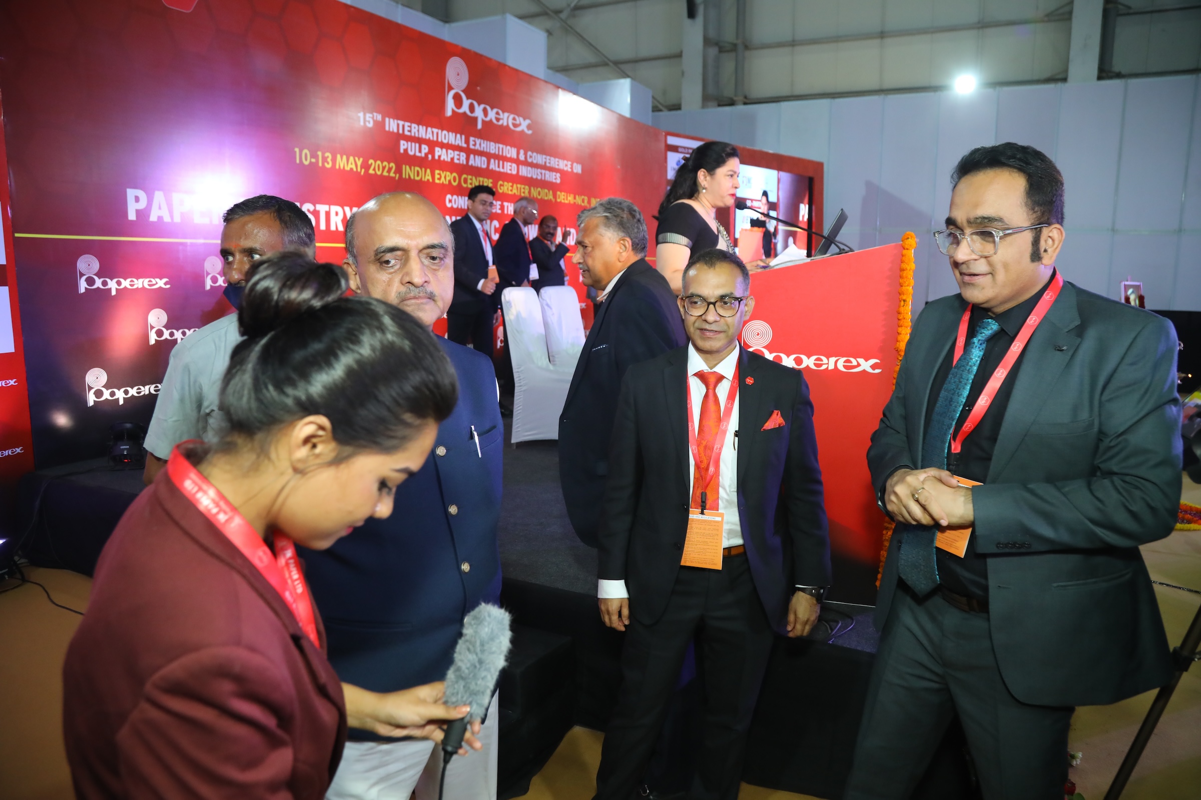 Attendees and speakers chatting before the start of a conference session.