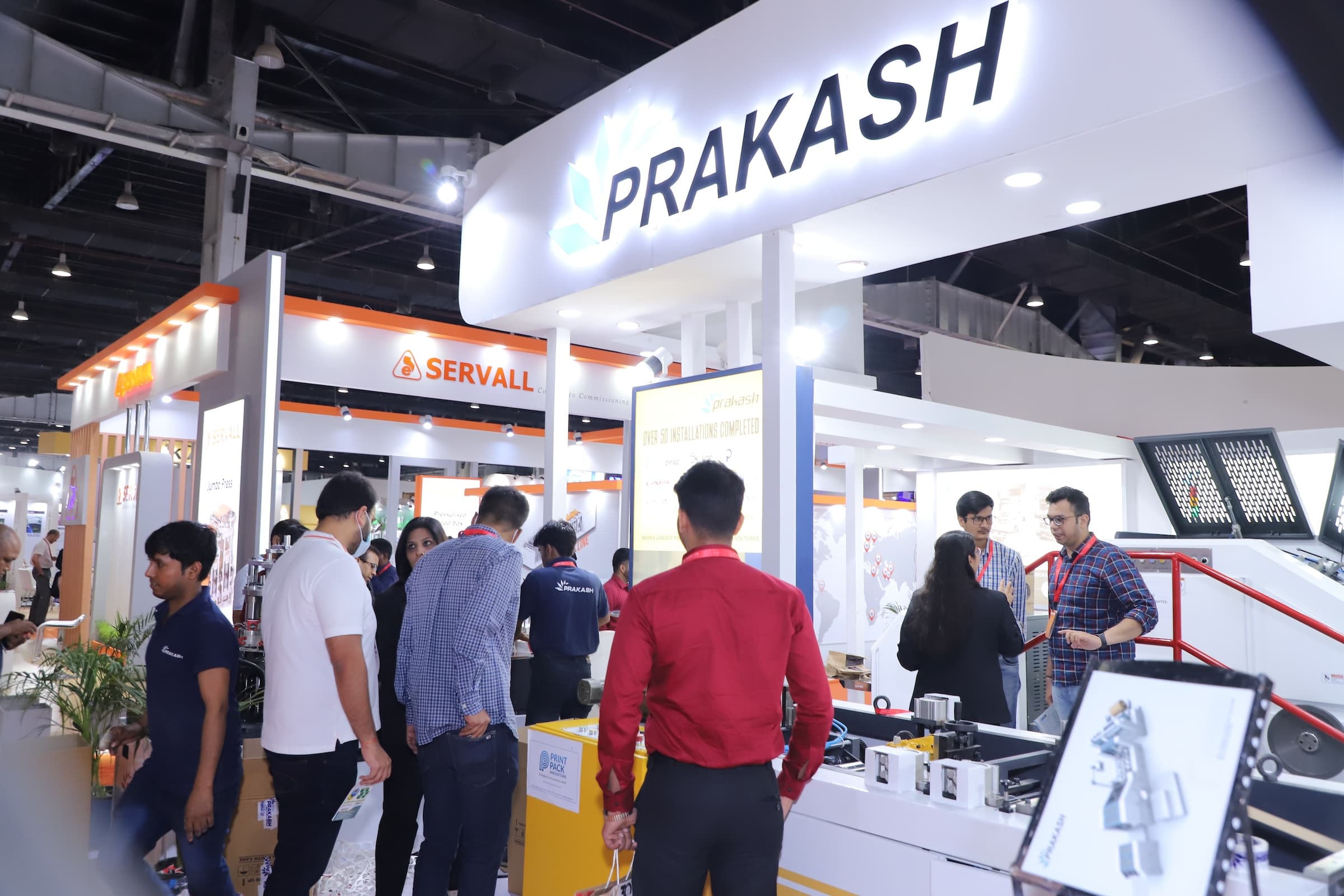 Prakash company booth at a trade show with visitors examining displays