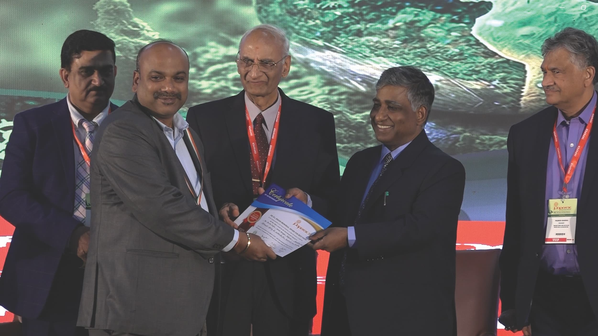 Business professionals at an award ceremony presenting a certificate.