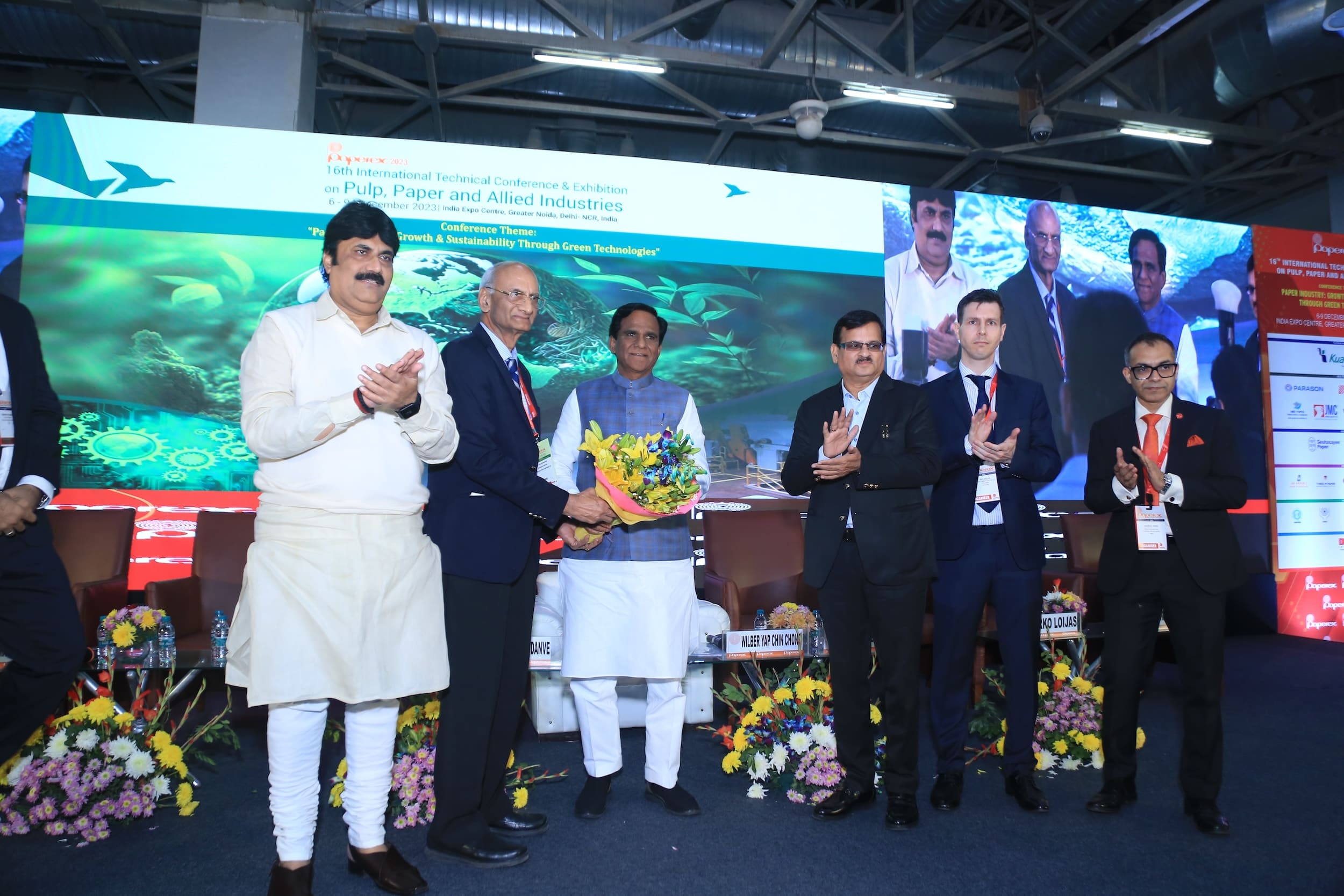 Conference attendees applauding during an award presentation ceremony on stage
