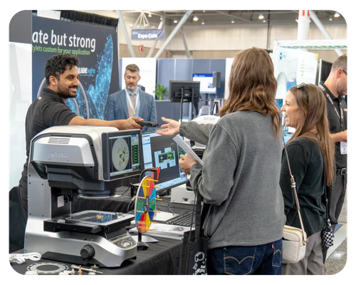 Attendees engage with an exhibitor at a trade show booth
