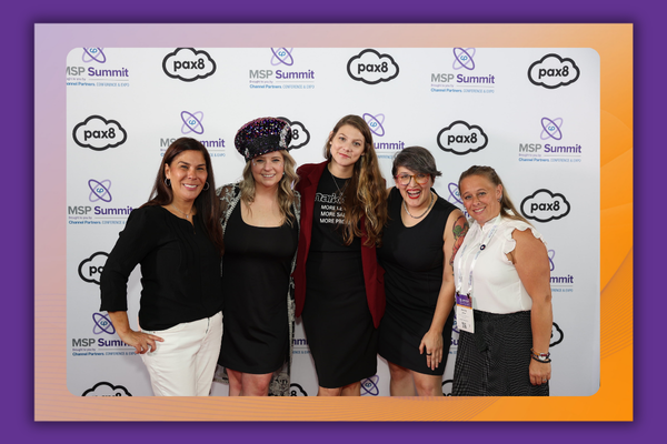 Attendees posing in front of Pax8 sponsored photo booth.