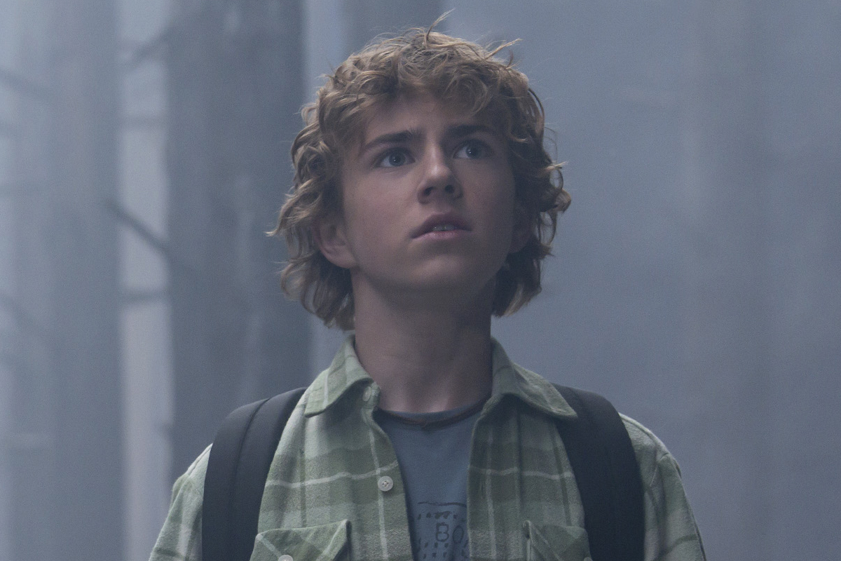 Percy Jackson looks concerned in the forest