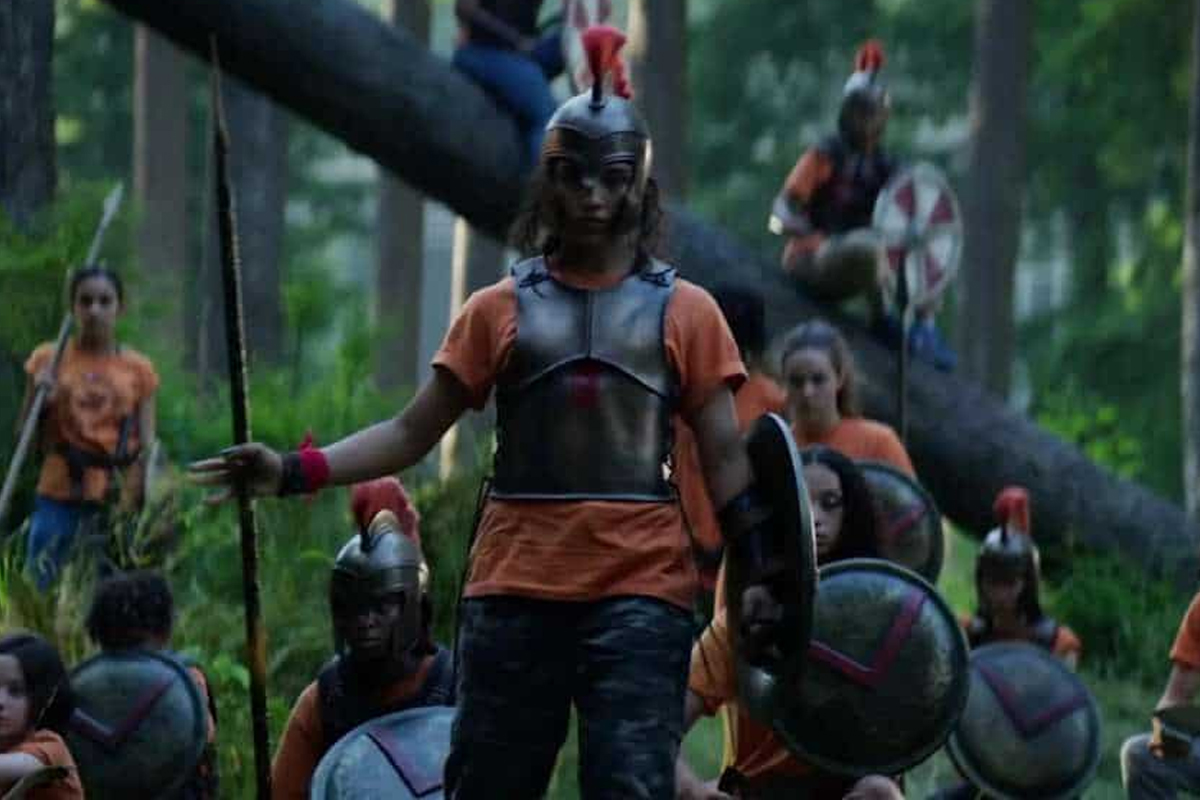 A group of campers stand in the forest