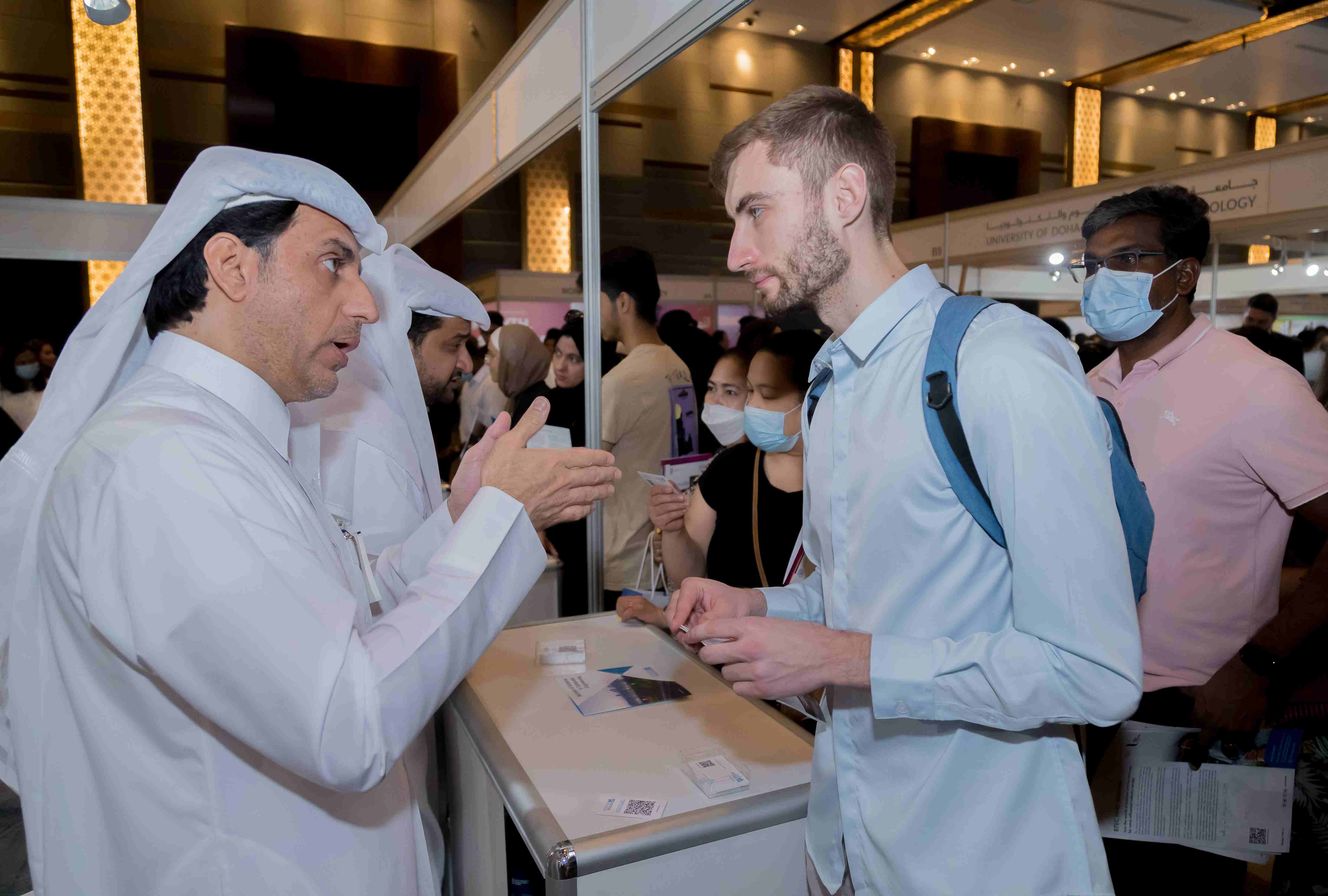 University representative speaks with Qatari parents and students about study abroad opportunities at Najah Doha fair.
