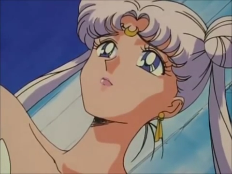 A close up on Queen Serenity's hair with her white hair flowing around her. The face she is making is one of pride.