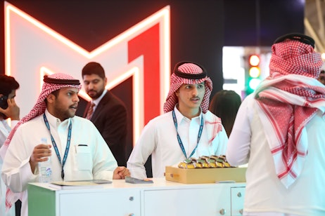 Exhibitors preparing product samples for display at SES 2025 in Riyadh