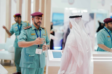 UAE police officer and Emirati visitor networking during Tawdheef x Zaheb 2025 in Abu Dhabi, strengthening public sector engagement.