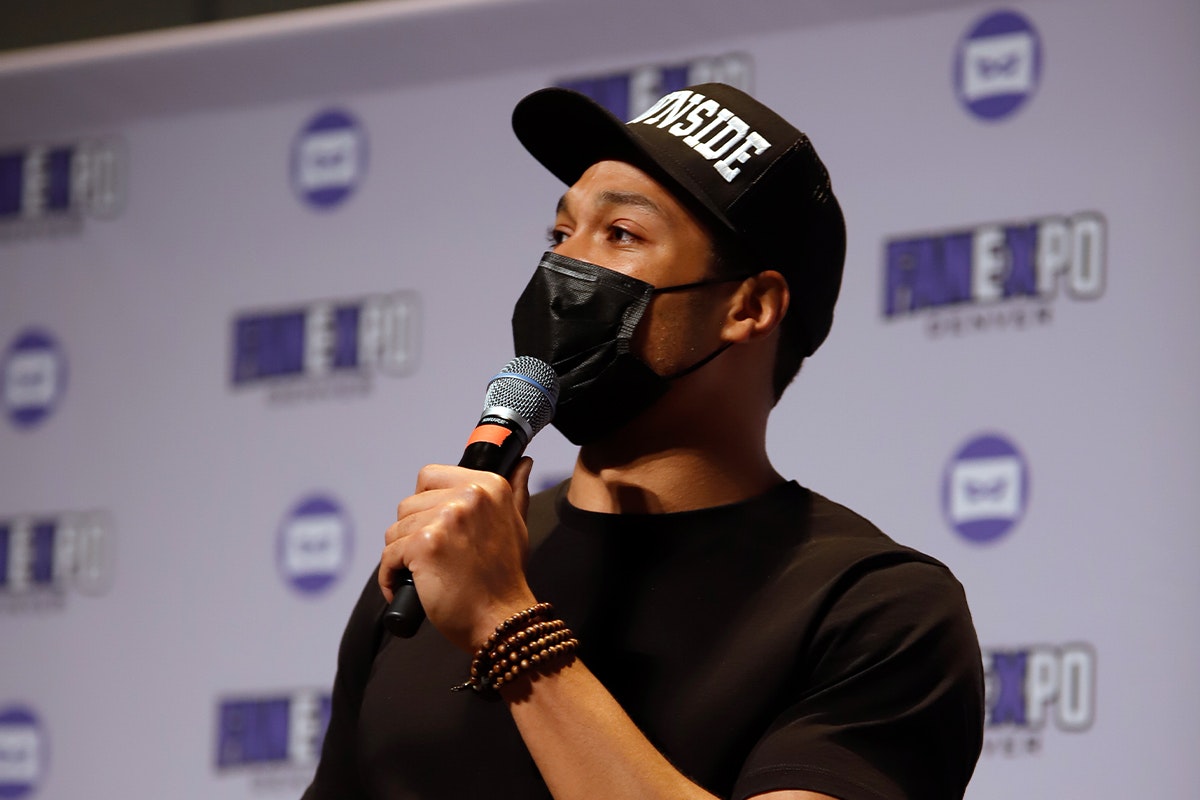 Ray Fisher answers a question on stage while speaking into a microphone