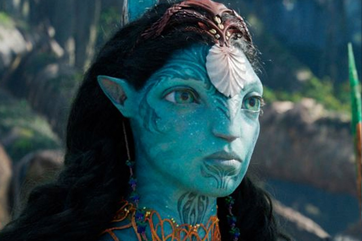 Ronal stands with a very serious look on her face and a shell mounted on her forehead