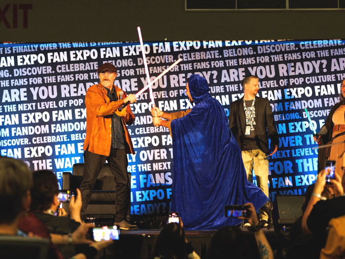 Michael Rooker with a fan on stage dueling lightsabers at FAN EXPO Vancouver