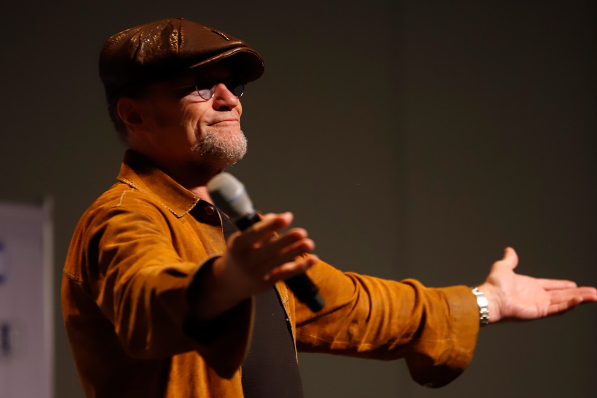 Michael Rooker stands with arms extended as he smiles at the crowd