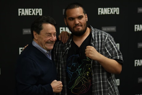 A fan posing for a picture with Peter Cullen