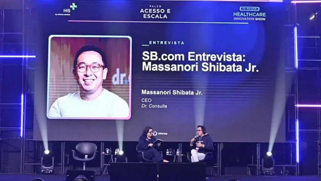 Palco do Healthcare Innovation Show com apresentação e entrevista a Massanori Shibata Jr., CEO do Dr. Consulta, sobre inovação na saúde.