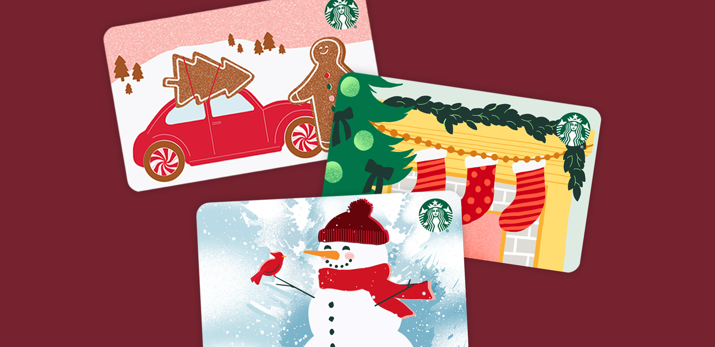 Three holiday themed Starbucks gift cards on top of a burgundy colored background.