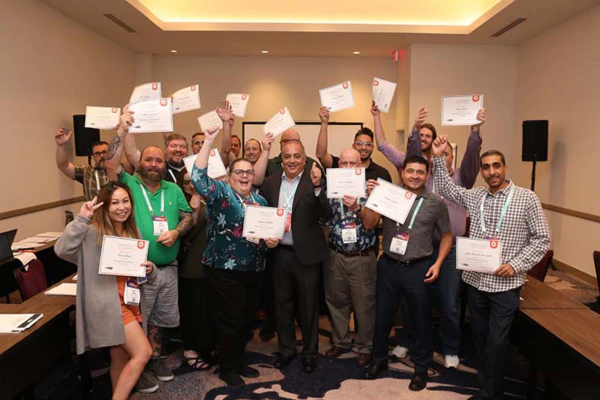 Students celebrate completing the HDI Support Center Director course with instructor Randy Celaya, holding their course completion certificates.