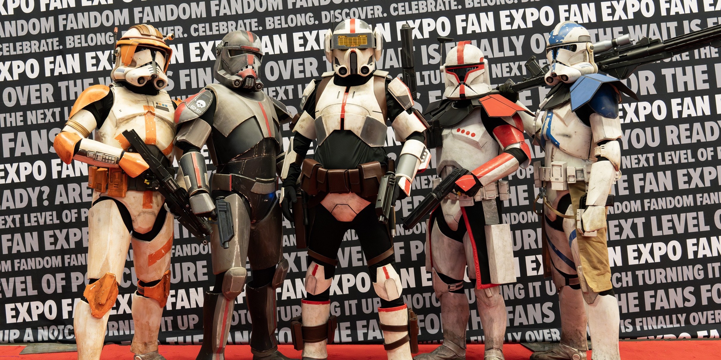 Five Star Wars cosplayers wearing detailed clone trooper armor pose together on the FAN EXPO Cleveland cosplay red carpet, standing side by side against a branded FAN EXPO backdrop.