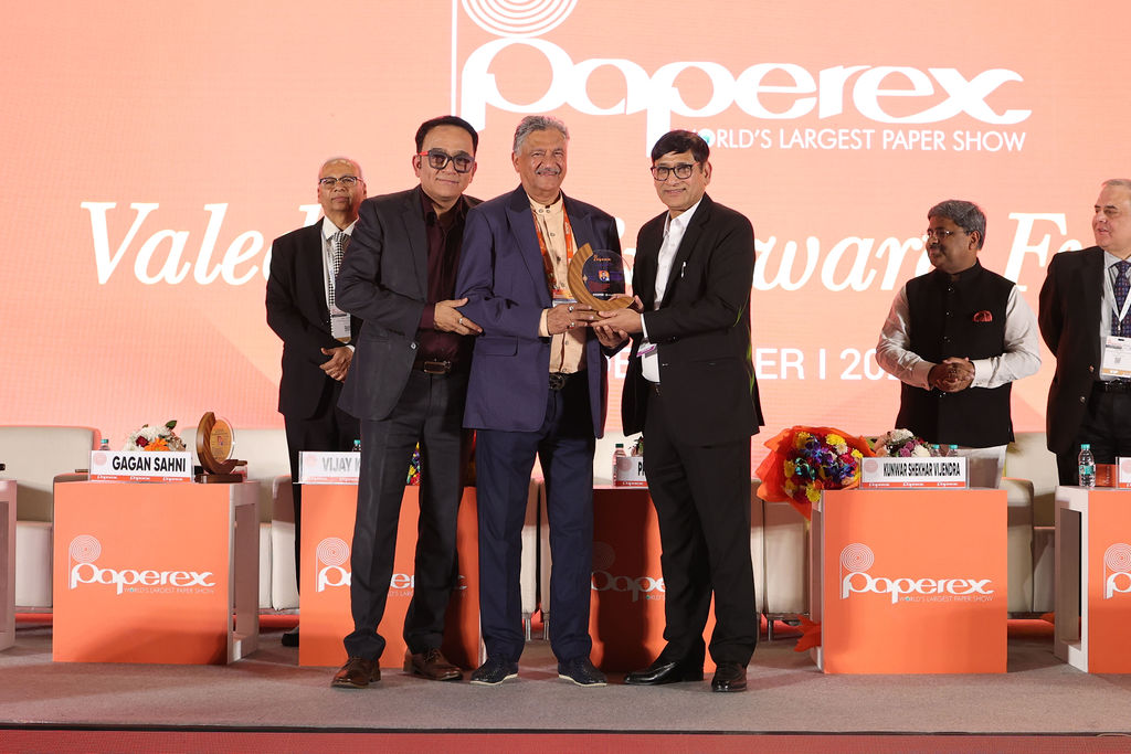 Group of professionals posing with an award at an exhibition booth