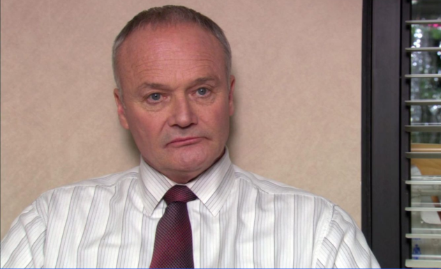 With his signature scowl, Creed sits in the interview office, staring at the camera crew off screen.