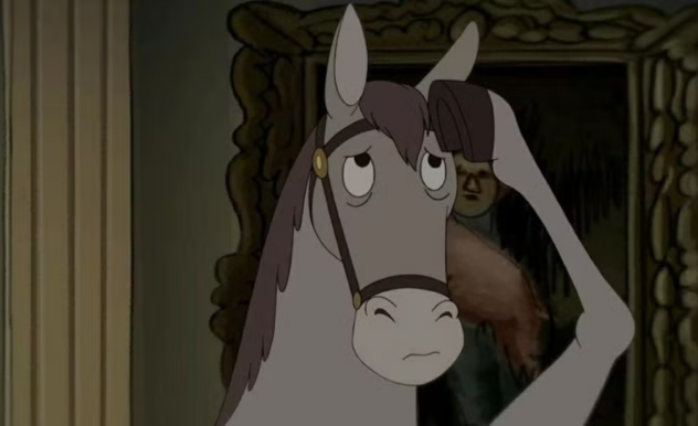 A grey horse stands in a hallway, using his hoof to wipe the sweat from his brow. 