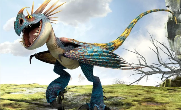 A tall, slender, blue and yellow dinosaur stands on a green field. It smiles wide, sending its nose horn back towards its quills