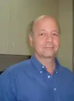 Retrato de Leandro Ribeiro, CISO e Diretor de Cibersegurança do Hospital Sírio-Libanês e ABCIS. Um homem jovem de óculos com armação preta, barba curta e expressão séria, posando de braços cruzados.