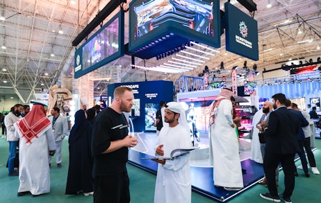 Attendees networking with exhibitors on the SES 2025 show floor in Riyadh