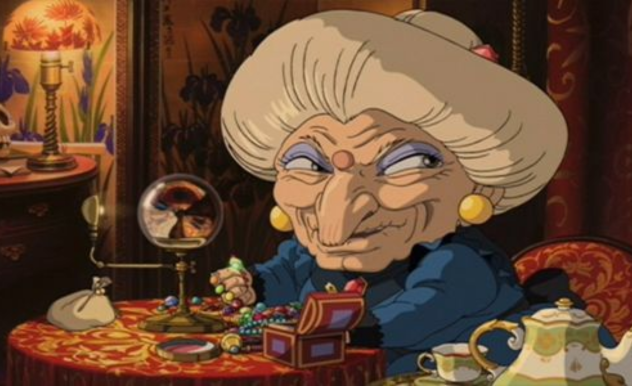 Yubaba, an elderly woman with hair larger than her head, sits in her chambers looking at her jewelry and enjoying a cup of tea.
