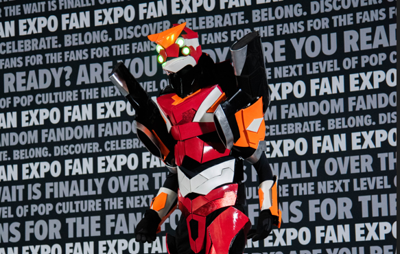 A fully lit and functional gundam poses as its eyes glow yellow