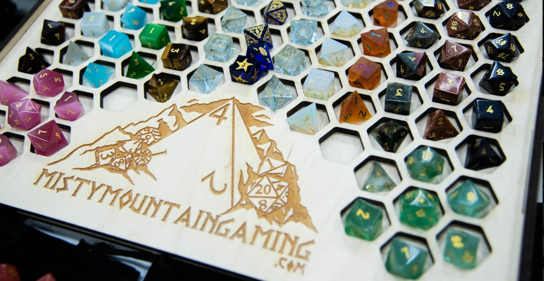 Misty Mountain Gaming dice organizing board with a selection of available dice sets in various rainbow colors