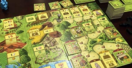 An Active game play of agricola the board is out and cards are in movement.
